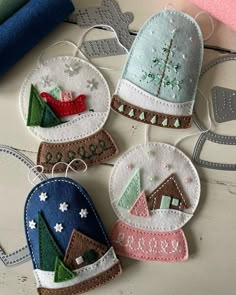 three handmade christmas ornaments on a table