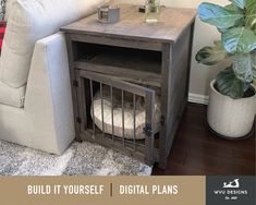 a dog crate sitting on top of a wooden table next to a white couch and potted plant