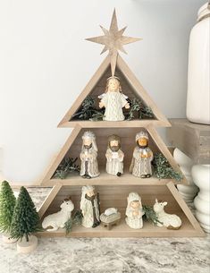 a wooden christmas tree with nativity figurines