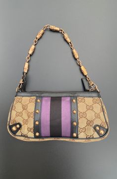 All Reserve items are final sale. This petit pouchette is a product of Tom Ford's helm at Gucci circa 05'/06'. Truly striking, with signature GG canvas and black leather trim, a purple/black stripes, and rose gold-tone hardware. A detachable chain strap, zip closure, and interior with an open pocket. Carry this style hand-held or on the forearm. Comes with dust bag. Condition: EXCELLENT/VERY GOOD Dimensions: Drop: 5.75" Height: 4" Width: 8" Depth: 1.5" *** Our scale is based on the following: Excellent Items look visually unused. Very Good Items show minor signs of wear. Good Items show moderate signs of wear. Shoes may show wear such as moderate scuffing at the soles, insoles and heels. Handbags and accessories may show wear such as worn corners, moderate scratches and interior wear. Fair Tom Ford For Gucci, Unique Purses, Chic Leather, Gucci Black, Purple Black, Leather Trim, Chain Strap, Tom Ford, Black Stripes