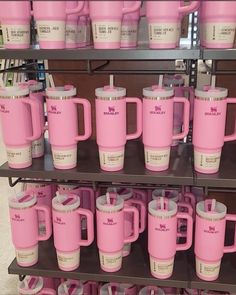 pink coffee mugs are on display in a store