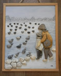 there is a painting on the wall with rocks and sand in it that has a person holding a bag