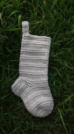 a knitted sock laying in the grass