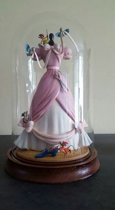 a snow globe with an image of a woman in a pink dress under glass on top of a table