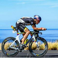 a man riding a bike down a road next to the ocean