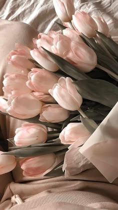 a bouquet of pink tulips on a bed