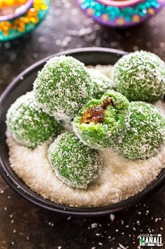 powdered sugar covered donuts in a black bowl