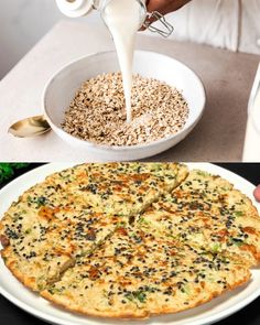 a person pouring milk over a pizza on top of a white plate next to a bowl of oatmeal