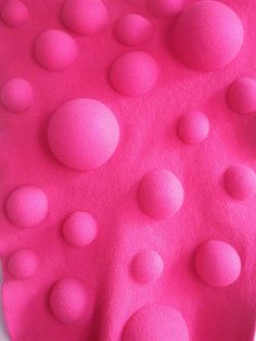 a close up of a pink object with lots of balls on it