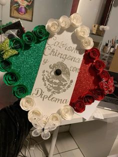 a heart shaped frame with the flag of italy and roses on it in front of a mirror