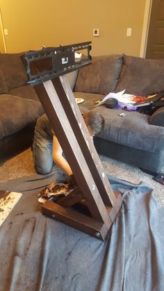 a person laying on the floor in front of a couch with a television set sitting on top of it