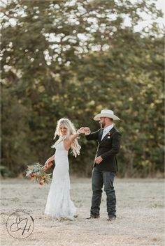 a bride and groom standing in the middle of a field