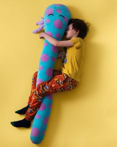 a little boy laying on top of a giant stuffed animal