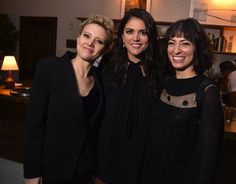 three women standing next to each other smiling