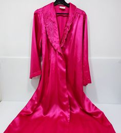 This vintage hot pink long satin robe from Liboria Creations is perfect for those special occasions. It elegantly drapes around your body, made with luxurious high quality satin fabric and is available in size large. Its classic design is an ideal fit for any woman and makes an excellent gift to show kindness and appreciation to your loved one. Stylishly structured, the robe has classic elements with a unique pink hue that will make you stand out. Get this made-in-Canada product now and experien Long Satin Robe With Satin Finish, Long Pink Silk Robe, Pink Satin Finish Robe For Wedding, Pink Satin Robe With Satin Finish, Pink Silk Wedding Robe, Pink Satin Party Robe, Elegant Long Pink Robe, Pink Long Sleeve Wedding Robe, Pink Silk Long Sleeve Sleepwear