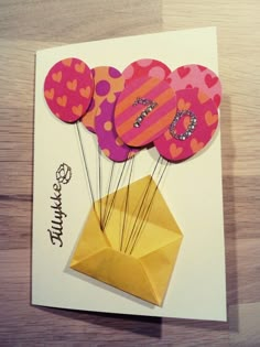 an origami birthday card with hot air balloons in a vase on a table