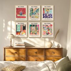 a bed room with a neatly made bed and posters on the wall