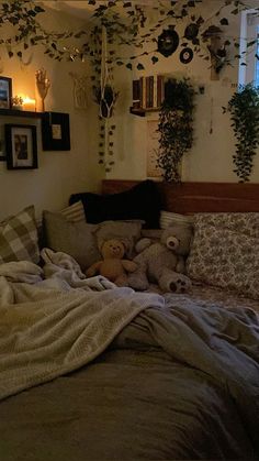 there is a teddy bear on the bed in this room with many plants hanging above it