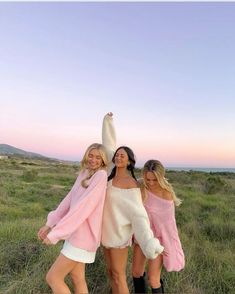 three women in pink and white outfits posing for the camera