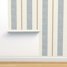 an empty room with blue and white striped wallpaper on the wall next to a shelf