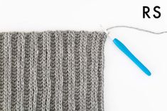 the knitting needle is hooked up to an object that looks like a knitted blanket