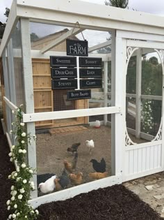 several chickens in a chicken coop with signs on the door and windows that say farm