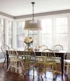 a dining room table with four chairs and a chandelier hanging from the ceiling