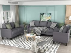 a living room filled with gray couches and green accent wall paint on the walls