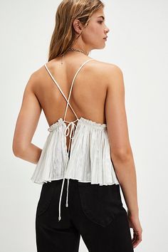 Effortlessly femme, this sleeveless top features a babydoll-inspired silhouette and deep V-neckline with gathered bodice detail and ruffled trim. **Fit:** Fitted bust, relaxed through the bodice **Features:** Shiny fabrication, deep V-neckline, defined underbust with ruffled trim, flowy gathered bodice, crisscross straps, self-tying back closure **Why We ❤ It:** This versatile top pairs perfectly with your favorite slouchy jeans or a sleek mini skirt. | Swan Song Tank Top by Free People in White, Size: XL Sleevless Top, Gathered Bodice, Slouchy Jeans, Swan Song, Ruffle Top, Cami Tanks, Boho Outfits, Free People Tops, Mini Skirt