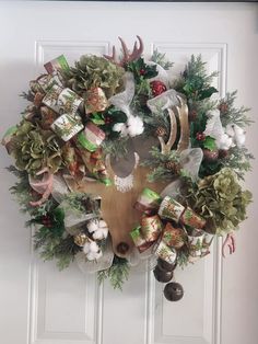 a christmas wreath with deer head, pine cones and bells on the front door handle