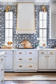 a kitchen with white cabinets and gold accents