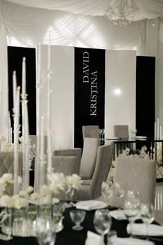 a dining room set up with white flowers and candles