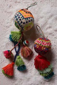 several colorful ornaments are laying on the floor together, including one ball and two tassels