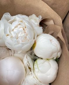 a bunch of white flowers in a brown paper bag