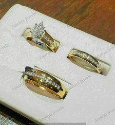 three different types of wedding rings sitting on top of a white box with gold trim