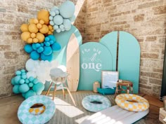 a room filled with balloons and decorations on top of a wooden floor next to a brick wall