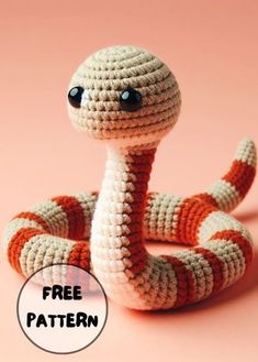 a crocheted snake sitting on top of a pink surface with the caption free pattern