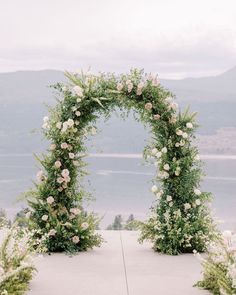 an outdoor ceremony setup with flowers and greenery