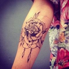 a woman's arm with a rose tattoo on it