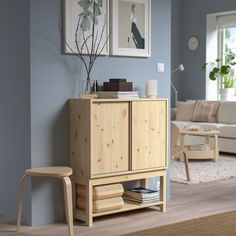 a living room scene with focus on the cabinet and chair next to it's footstool