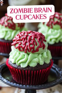 two red and green cupcakes on a black plate