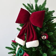 a christmas tree decorated with red and green ornaments, including a santa hat ornament