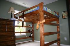 a wooden bunk bed sitting in a bedroom next to a dresser