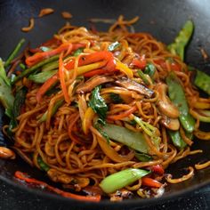 a wok filled with noodles and vegetables