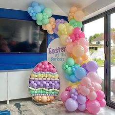 there are balloons on the table and in front of the television set that says easter at the baxters