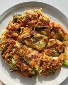 a white plate topped with vegetable fritters on top of a wooden cutting board