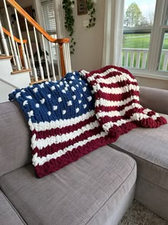 the american flag crocheted throw pillow is sitting on a couch