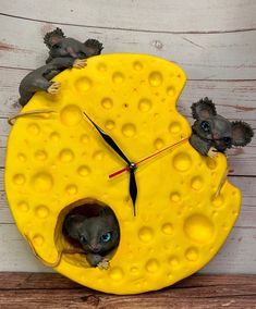 a clock made to look like cheese with mice on it's face and inside the cheese