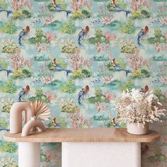 the wallpaper is very colorful and has birds on it, while flowers are in vases