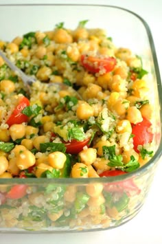 a salad with chickpeas and tomatoes in a glass dish